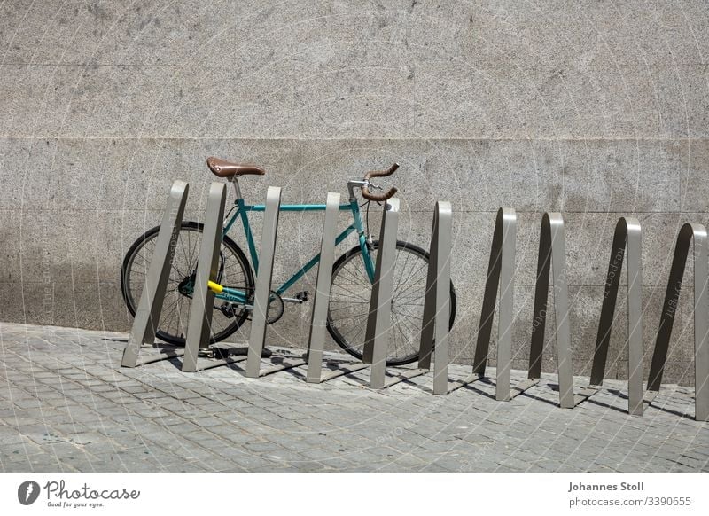 Rennrad an Fahrradständer vor grauer Wand Türkis blau grün Rad fahrrad Fixie rennrad citybike bicycle Reifen rahmen lenker mantel ventil klingel Ständer