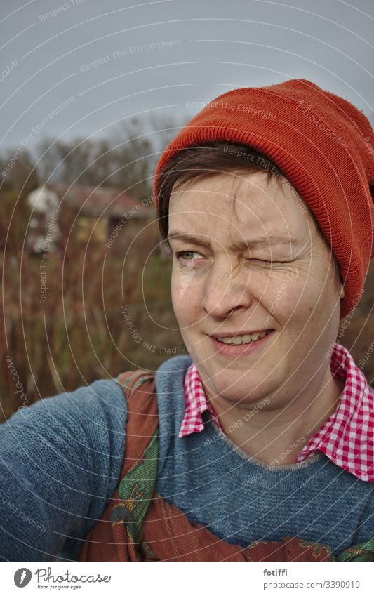 Startklar für die Gartenarbeit Natur Außenaufnahme blinzeln Zwinkern Frau Mütze Tragetuch Porträt feminin Erwachsene selfie