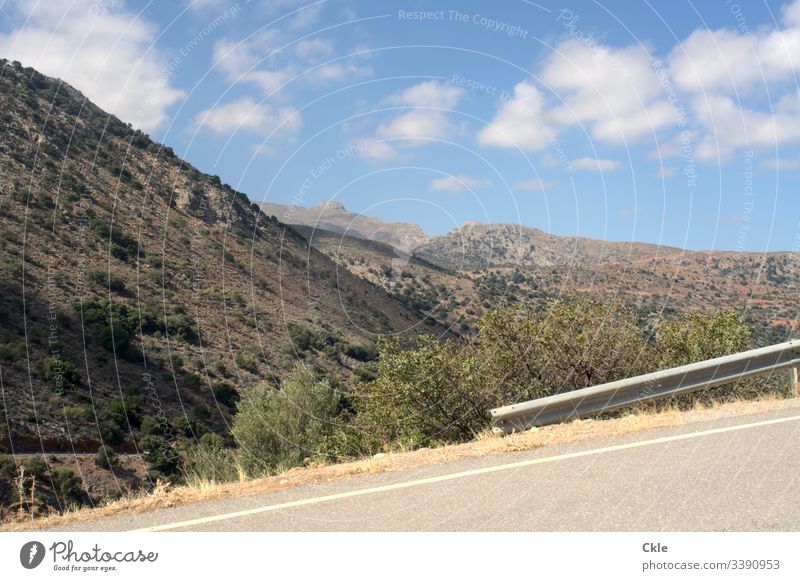 Einsame Straße in Bergen der Insel Kreta Gipfel Abgrund Leitplanke Sommer Dürre Einsamkeit Blauer Himmel Wolken Griechenland Weitwinkel Panorama Aussicht