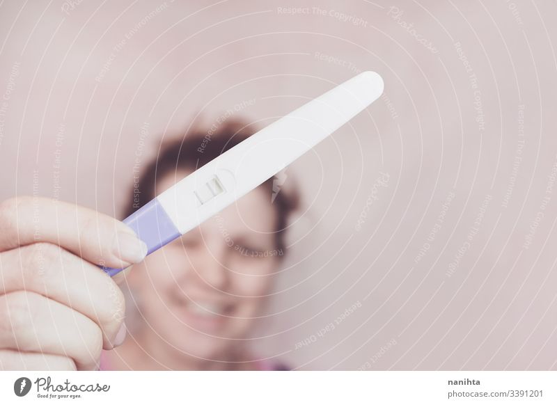 Junge glückliche Frau mit positivem Schwangerschaftstest schwanger Mama Prüfung Mutter Familie Glück Fröhlichkeit Stimmung Emotion gefühlsbetont Optimismus