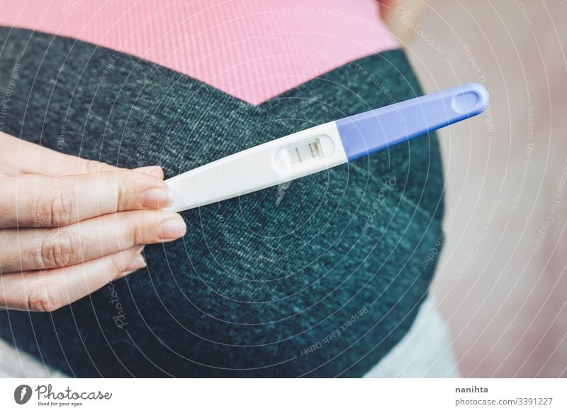 Frau mit einem positiven Schwangerschaftstest schwanger Prüfung Mama Mutter Familie Fröhlichkeit Glück rosa abschließen Bauch Monat Woche dritte Beweis Liebe