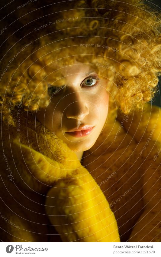 junge Frau mit blonden Locken und gelbem Kunstpelzmantel Schminke Maskenbildner Junge Frau Mode stylisch Straßenkunst Streetstyle trendy flur Pelzmantel