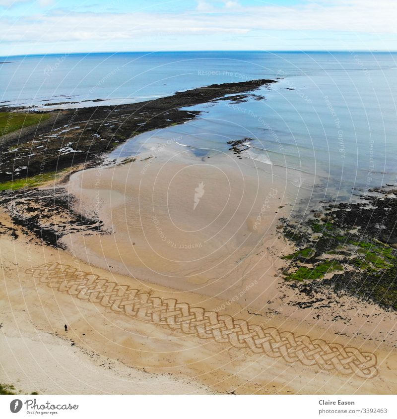 Riesige Sandkunst Keltische Knotenarbeiten entlang eines Strandes mit einer Person für die Waage, die mit einer Dji-Kamera erstellt wurde Riese