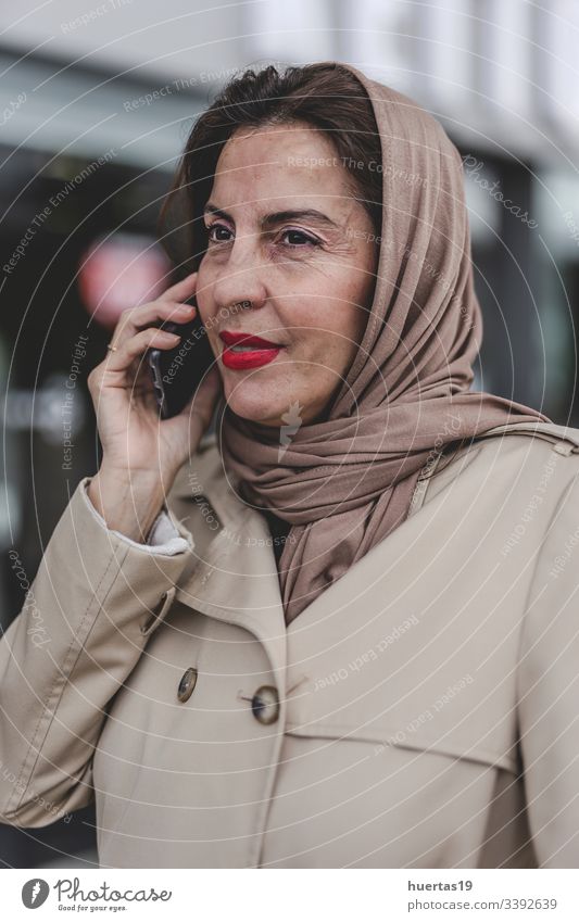 Arabische Frau mit Hidschab am Telefon Hijab attraktiv Koffer muslimisch muslimische Frau Handy arabisch Gepäck Reisen: islamisch Reisender Ausflug Fröhlichkeit