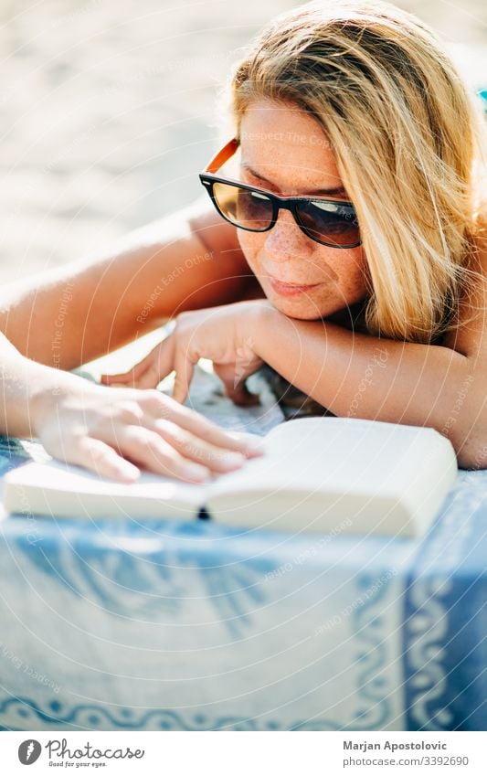 Junge Frau liest ein Buch am Strand liegend attraktiv schön Schönheit Bett blond lässig Kaukasier Nahaufnahme niedlich Tag genießen Sommersprossen Mädchen