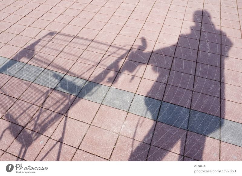 Schattenperson mit Einkaufswagen Schattenspiel Person kaufen Sonnenlicht Tag Menschenleer Farbfoto Parkplatz Kacheln Quadrat Perspektive Plan Oberfläche Spaß
