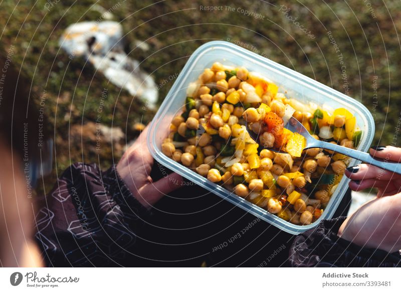 Reisende essen hausgemachten Salat, während sie sich in der Natur ausruhen Frau Mittagessen Wanderung reisen Tourismus Pause Lager Salatbeilage Container