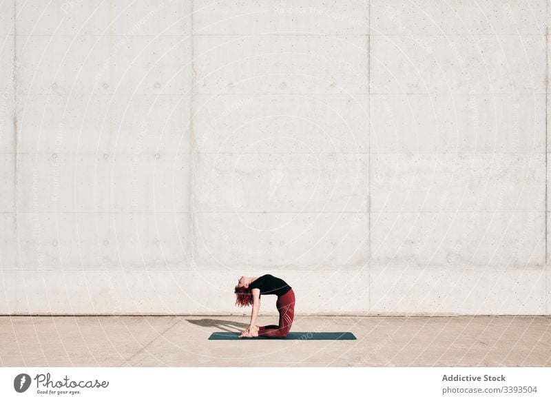 Frau macht Yoga in Kamelpose auf der Straße Dehnung üben Asana Training Übung beweglich Athlet Windstille gymnastisch Beton urban Wellness Wohlbefinden
