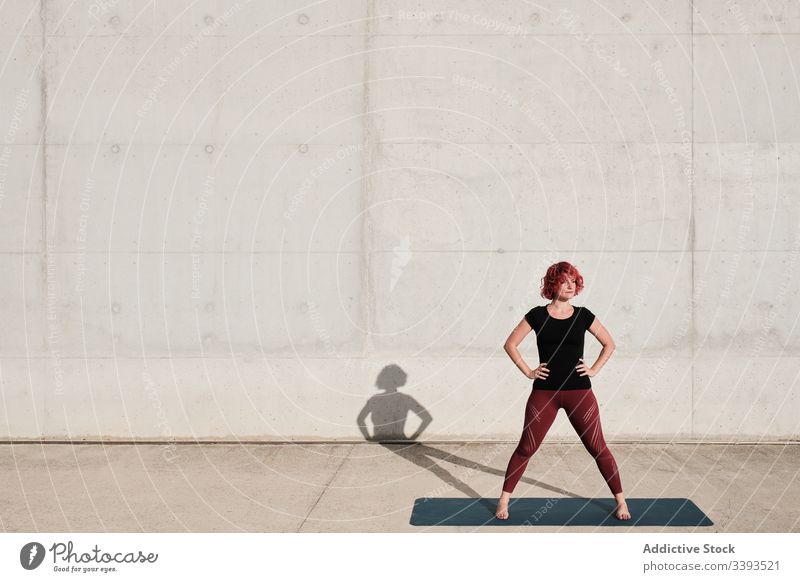 Sportlerin, die sich nach dem Training stehend auf Yogamatte ausruht Frau Straße Athlet besinnlich Denken passen ruhig selbstbewusst nachdenklich trendy