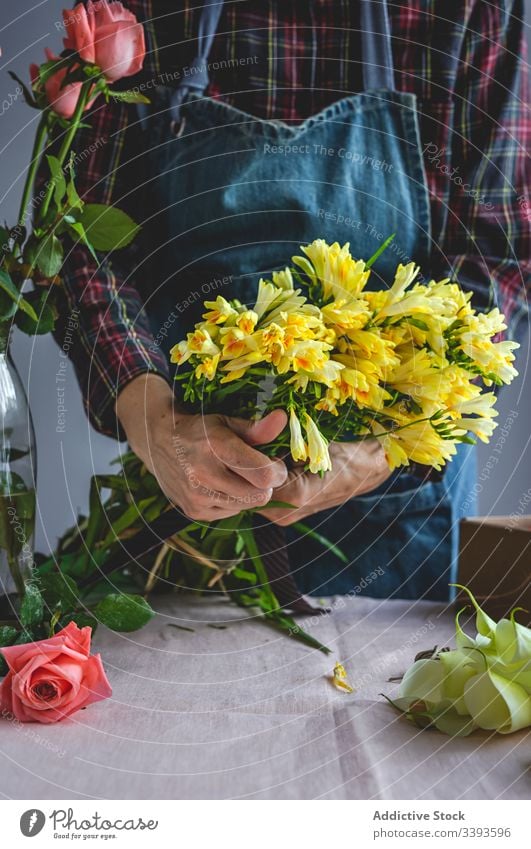 Nicht erkennbare weibliche Berufsfloristin, die Blumensträuße fertigt. Überstrahlung Hintergrund Besitzer Zusammensetzung schön Blumenstrauß kreativ geblümt