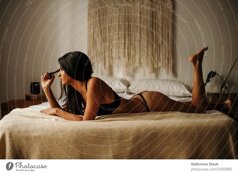 Verlockende Kropfendame in Dessous auf dem Bett liegend Frau Unterwäsche sinnlich Windstille Verlockung Körper schwarz Lügen Komfort Frauenunterhose