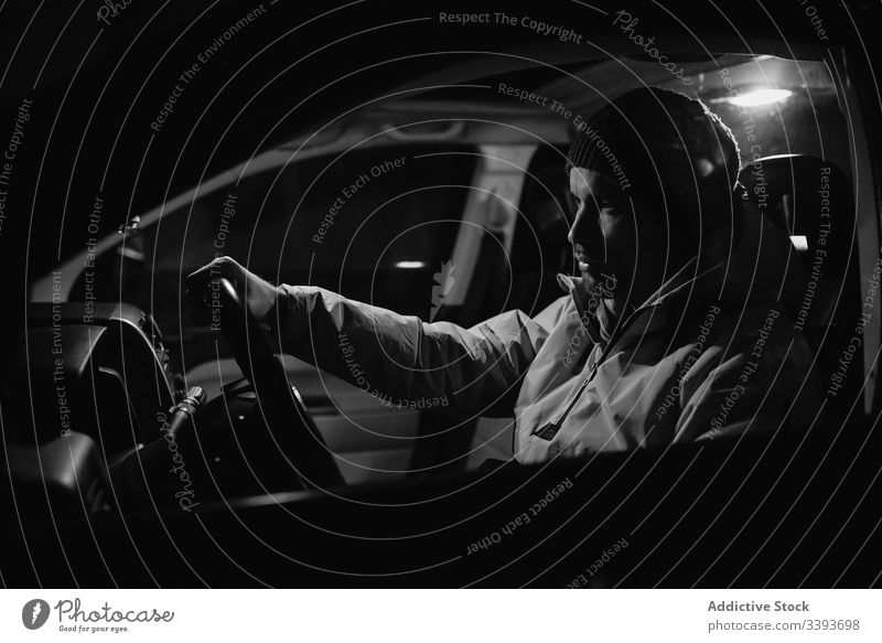 Fokussierter Mann fährt nachts Auto Laufwerk PKW Nacht Lenkrad Mitfahrgelegenheit Fahrzeug Verkehr reisen Reise männlich Kontrolle Straße Geschwindigkeit modern