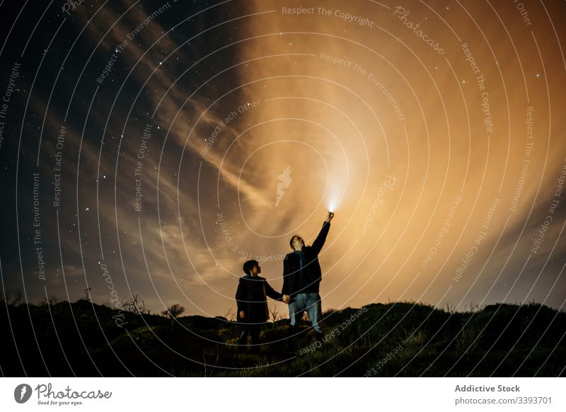 Fürsorglicher Vater unterrichtet Sohn nachts in Astronomie Nacht Himmel beobachten Stern lehren Papa sternenklar zeigen Licht Fackel Händchenhalten männlich