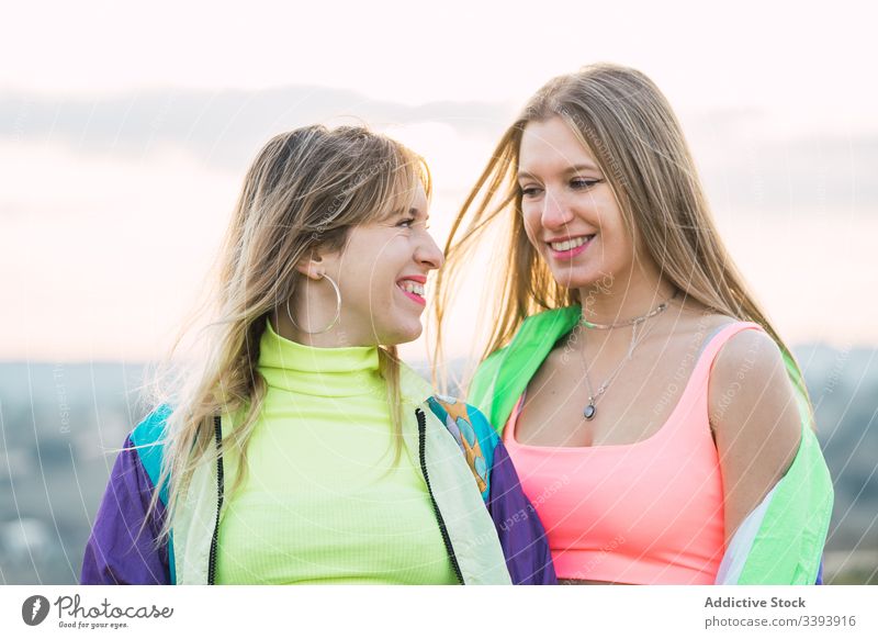 Coole moderne Frauen plaudern auf ländlichem Feld Hipster Teenager Freundin farbenfroh cool Menschengruppe anhaben Kleidung auflehnen Lächeln Lachen genießen