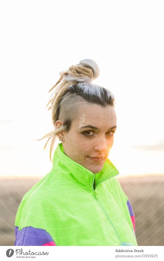 Junge Frau mit moderner Frisur in farbenfroher Sportkleidung Teenager Hipster Sportbekleidung außergewöhnlich besinnlich cool Natur Jacke gefärbtes Haar