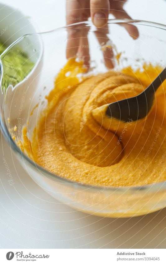 Frau rührt bei Tisch Gemüsepüree in Schüssel um Koch Püree Mischung orange Glas Küche Gesundheit Lebensmittel Veganer Mittagessen selbstgemacht