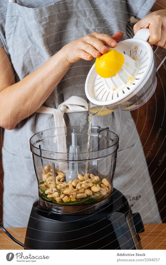Erntehelferin gibt Zitronensaft in den Mixer Frau Mischer Koch Saft verschütten Entsafter Cashewnuss Küche Veganer Gesundheit Speise Küchengeräte Vorrichtung