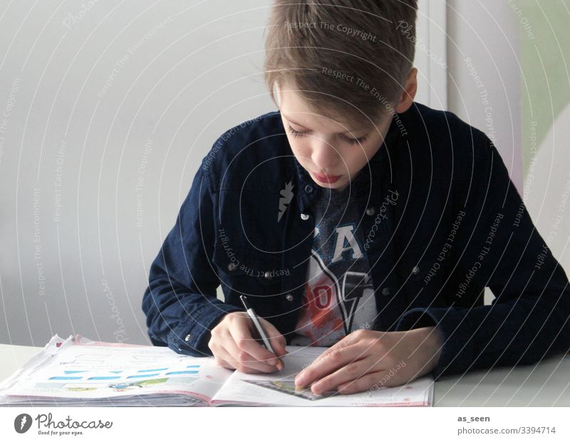 Junge macht Hausaufgaben blond hair Haare & Frisuren Stift Bleistift Gesicht Blick Porträt Blick nach unten schreiben schreibend Jugendliche konzentriert
