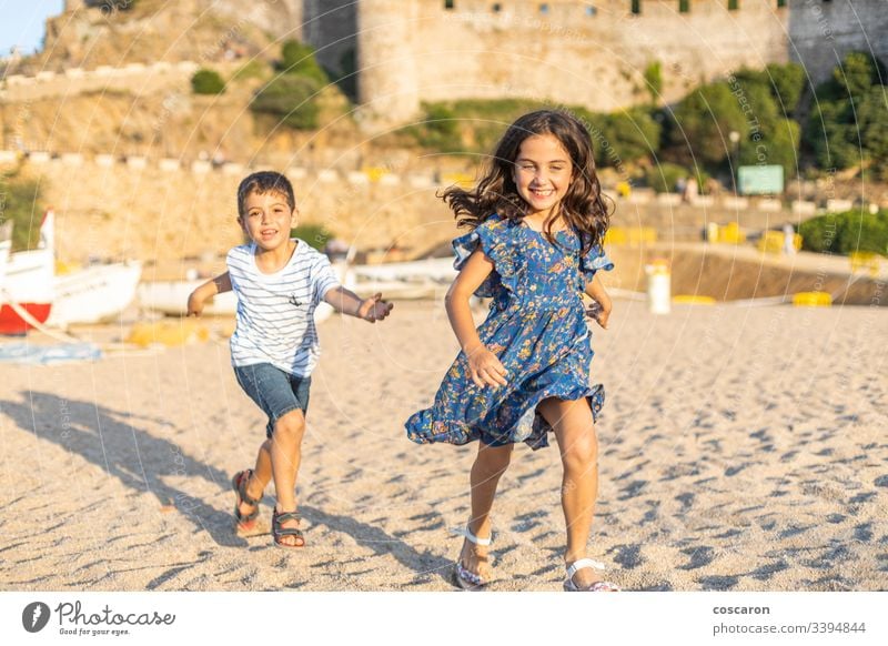 Zwei kleine Freunde laufen am Strand Aktion aktiv schön blau Jungen heiter Kind Kindheit Kinder bunt Konkurrenz Konzept niedlich Freundschaft Spaß lustig