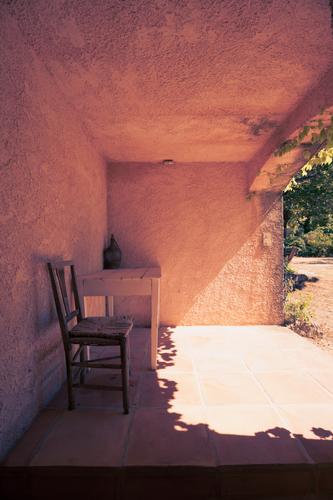 Schattenplatz mit Tisch und Stuhl auf einer überdachten Terrasse Sommer Sonnenstrahlen Haus Landhaus Wohnen Süden Garten pergola Menschenleer Tag Farbfoto