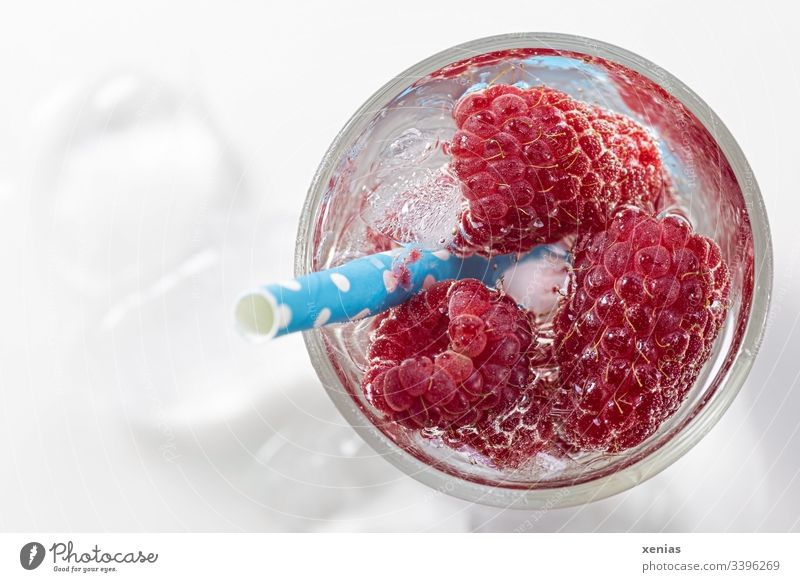 Kühles Erfrischungsgetränk mit Himbeeren, Eiswürfel und Trinkhalm Nahaufnahme lecker rot kalt Gesunde Ernährung Frucht Getränk Glas Vitamin Foodfotografie