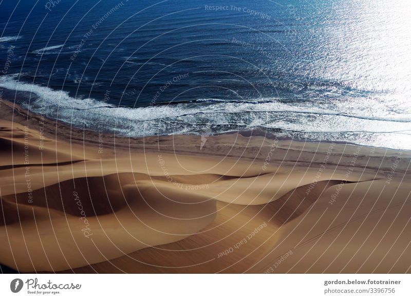 Sanddünen erobern das Meer Tageslicht Landschaftaufnahme wenig Farbe Menschenleer Schatten Licht Wasser und Sand Natur