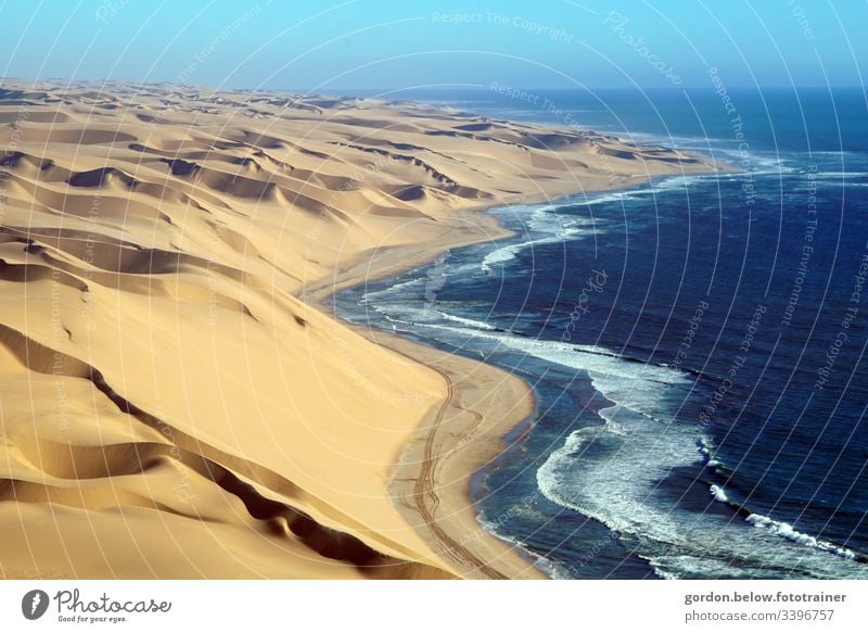 Sanddüne küsst Meer Natur Sanddünen Tageslicht Außenaufnahme Sommer wenig Farbe blau braun Schatten Menschenleer Ferien & Urlaub & Reisen Wellen Erholung