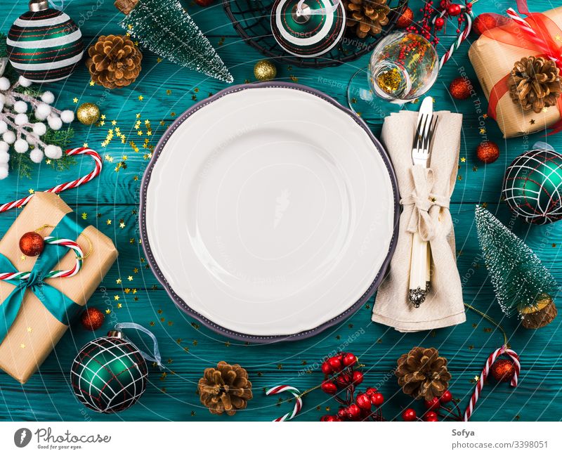 Weihnachten dunkler Hintergrund mit leerer Schale auf smaragdgrünem Holztisch voller festlicher Ornamente, Geschenkschachteln und Zuckerstangen Neujahr