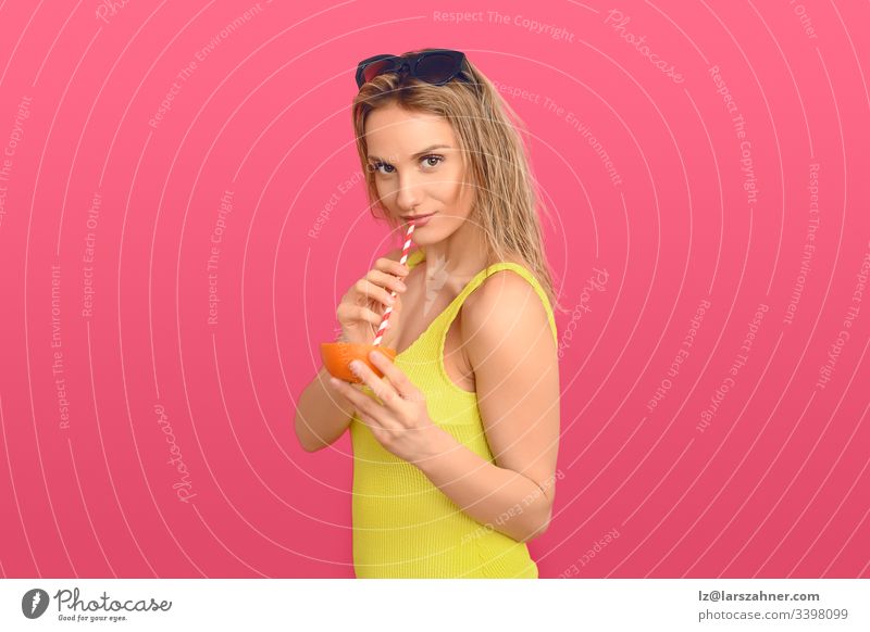 Frau trinkt durch den Strohhalm einer Orange attraktiv schön Cellulite-Behandlung heiter Cocktail farbenfroh Konzept konzeptionell lecker Diät trinken Ausdruck