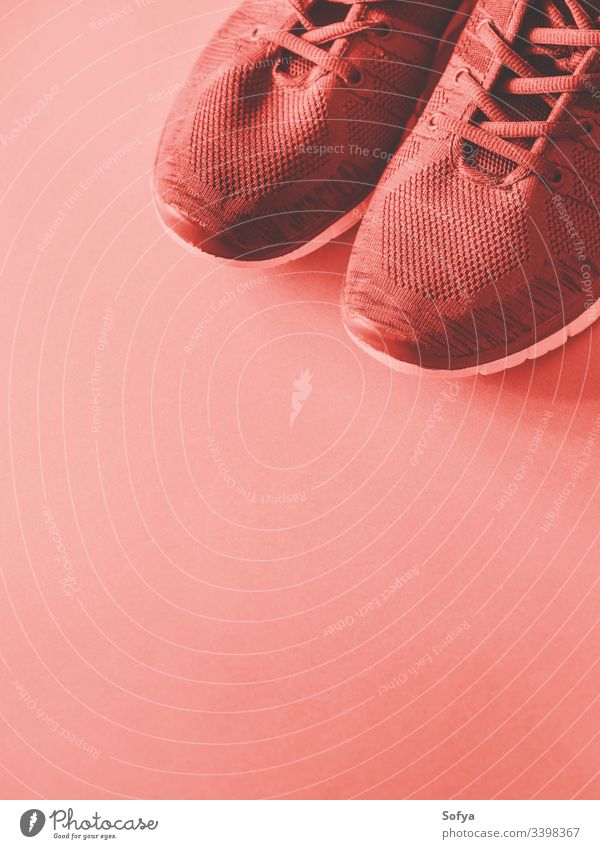 Sporttrainer auf leerem Hintergrund. Roter Korallenton Schuhe Farbe rosa rot Fitnessstudio Turnschuh Spaziergang Training hell Ausbilder Übung Lifestyle laufen