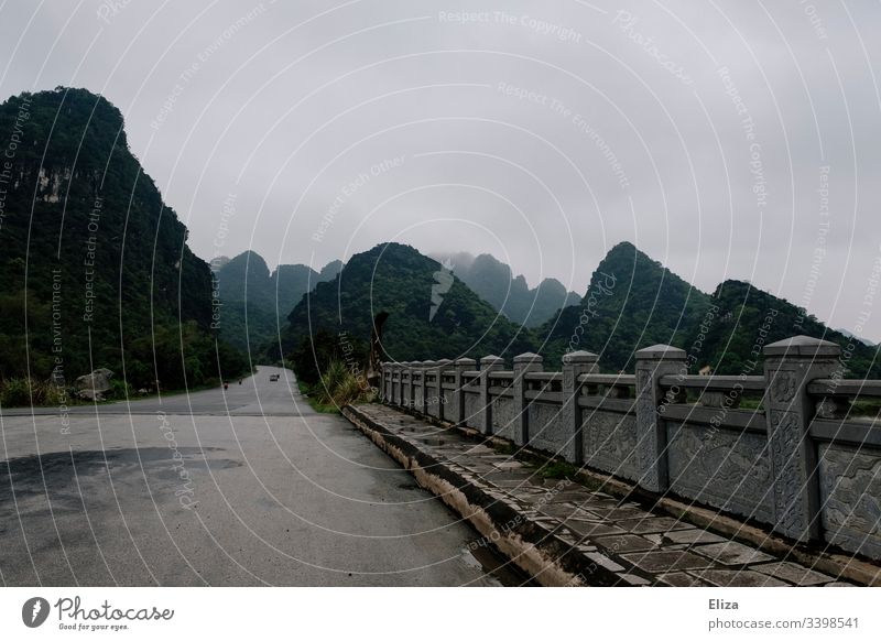 Eine Steinbrücke vor einer wunderschönen Berglandschaft mit Kalksteinfelsen in Ninh Binh, Vietnam Landschaft Berge Straße Reisen Ferien & Urlaub & Reisen