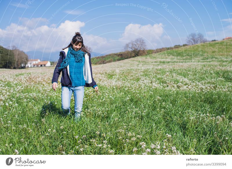 Frontansicht einer brünetten hispanischen Frau in Freizeitkleidung, die auf dem Feld geht Blume grün Rücken Freiheit Frühling 1 Ansicht Natur allein Sommer