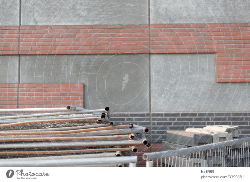 Baustellenabsperrung vor Betonwand mit Teilklinkerung Barke Zaun Absperrung graue Wand Zäune eingezäunt Metallzaun Schranke Sicherheit Schutz
