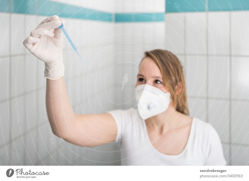 Krankenschwester mit Mundschutz untersucht Laborprobe Coronavirus COVID-19 Virus Krankheit Pandemie Epidemie Maske Schützen Einmalhandschuhe Handschutz Steril