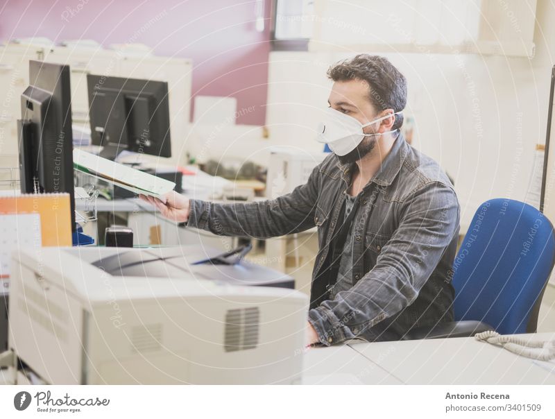 Mann, der mit einer medizinischen Maske, einer Allergie oder einem Krankheitsbild arbeitet Mundschutz Büro Arbeiter Büroangestellte Aktenordner wirklich