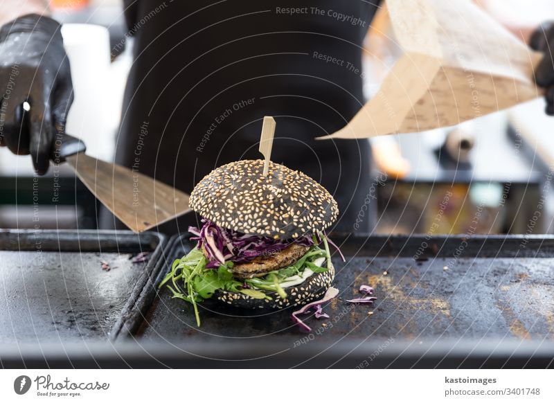 Küchenchef bereitet Burger auf einer Grillplatte auf dem internationalen städtischen Straßenessen-Festival vor. Hamburger Fleisch Fisch Mann Mahlzeit Grillrost