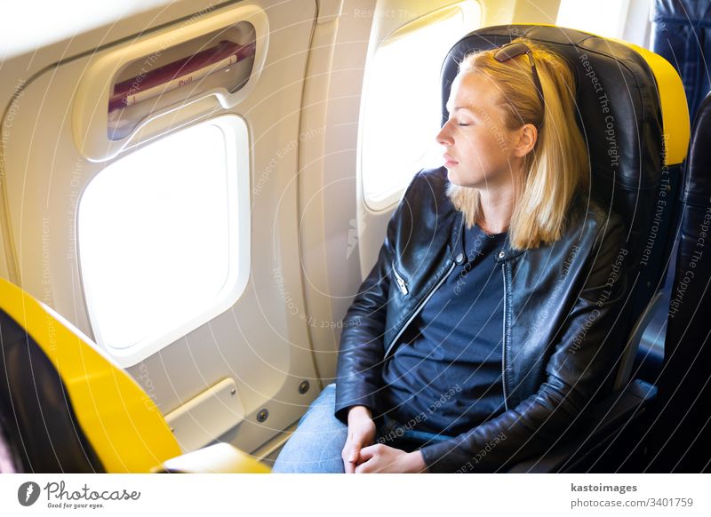 Müde blonde, lässige, kaukasische Dame, die auf dem Sitz schläft, während sie mit dem Flugzeug reist. schlafen Frau Ebene reisen Business Wirtschaft Stress