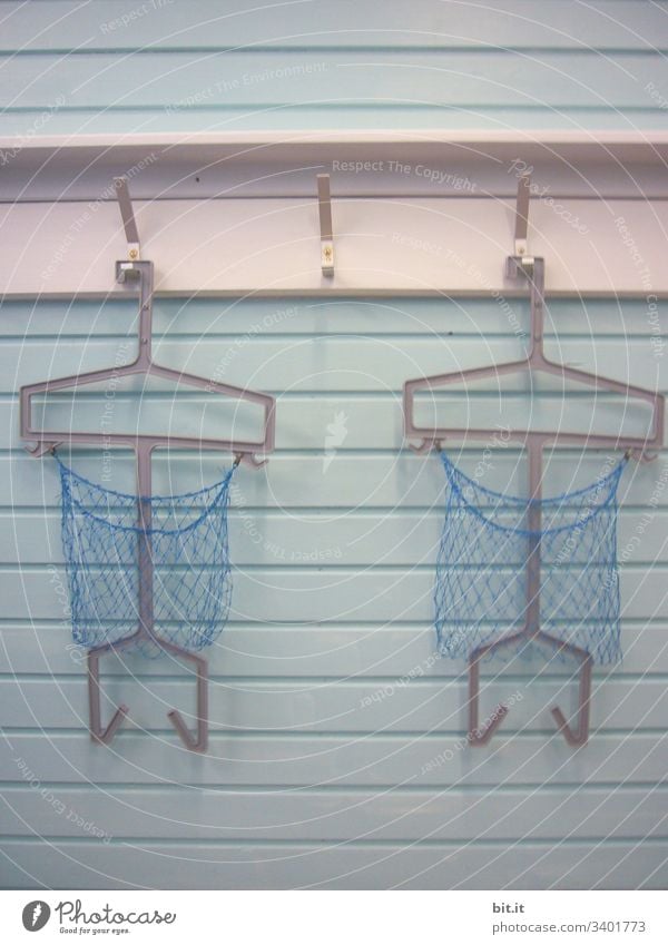 Drei leere Haken mit Garderobenbügel und Netz, an weißer Gaderobe, im geschlossenen Schwimmbad Schwimmen & Baden Schwimmsport Garderobenhaken garderobe