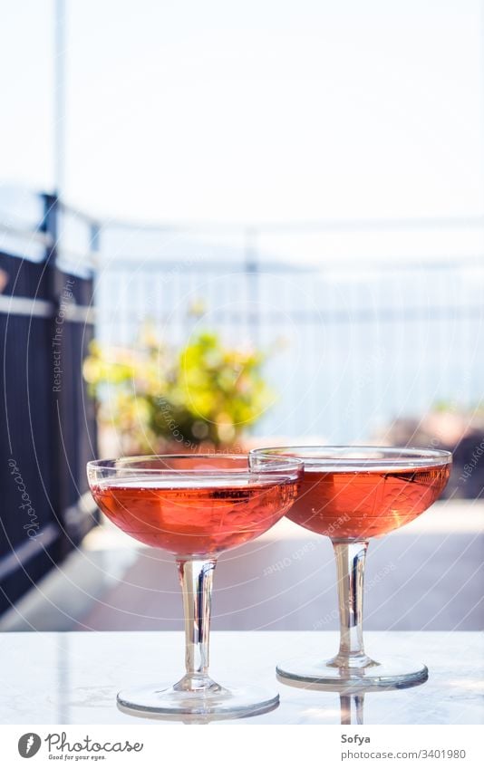 Zwei Kristallstielgläser mit Rosenwein im Freien auf Marmortisch. Aperitifzeit Wein Roséwein weiß Glas Murmel Party rosa trinken Abendessen Tisch Reichtum Licht