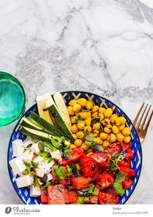 Kichererbsen-Wassermelonensalat mit Feta und Tomaten, Zucchini und Kürbiskernen Lebensmittel farbenfroh Salatbeilage Kurkuma Käse Draufsicht flache Verlegung