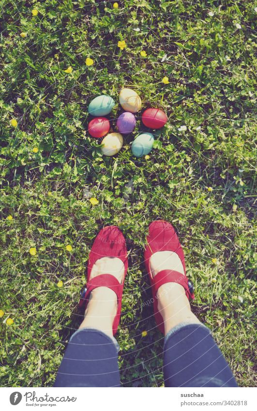 frau steht auf dem gras vor bunten ostereiern Frau stehen Beine Füße Damenschuhe rot Ostern Ostereier farbig gefärbt Schuhe bunte Eier gekochte Eier