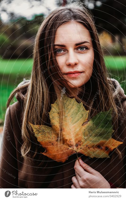 Hübsches Mädchen hält ein Blatt mit Herbstfarben launisch Frau Beteiligung portret Stimmung braun Farben bekleidet Ausdruck Gesicht Schönheit Natur Mode 20s