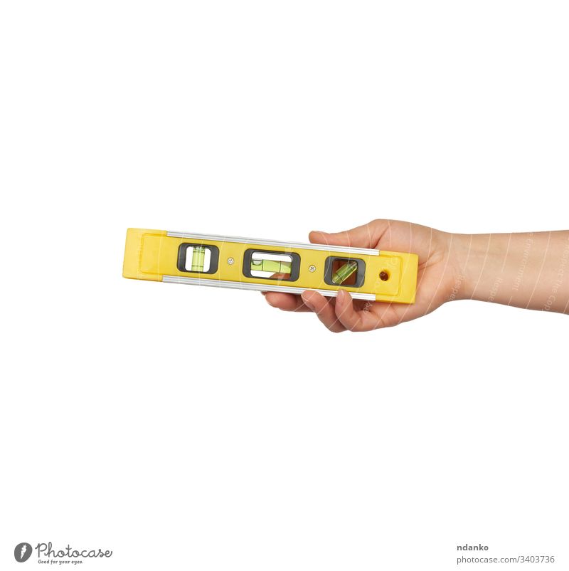 gelbes Plastikwerkzeug mit isolierten Kapseln auf weißem Hintergrund Hand Halt Bauherr Genauigkeit genau Ausrichtung Winkel Gleichgewicht Schaumblase bauen