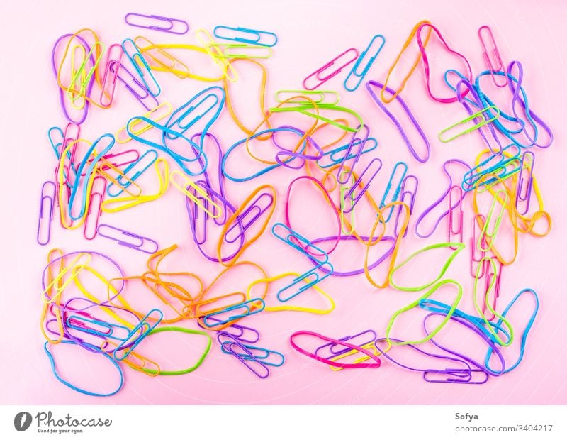 Bunte Gummibänder auf rosa Papierhintergrund Gummiband Schreibwarenhandlung Clip Büro Farbe flache Verlegung Gummiring Mädchen Stil Arbeitsbereich Vorrat lernen