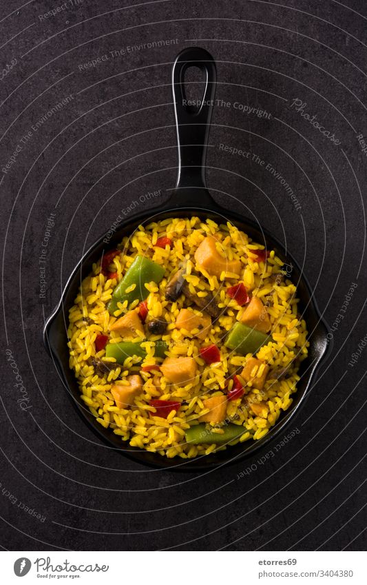 Gebratener Reis mit Hühnchen und Gemüse in der Pfanne auf schwarzem Hintergrund - Draufsicht asiatisch Hähnchen Chinesisch gekocht Küche lecker Speise