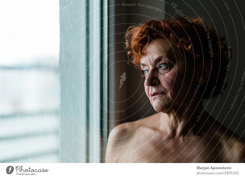 Reife Frau am Fenster, die über das Leben nachdenkt Erwachsener Lebensalter gealtert Alterung allein schön Schönheit Pflege Kaukasier Nahaufnahme betrachtend