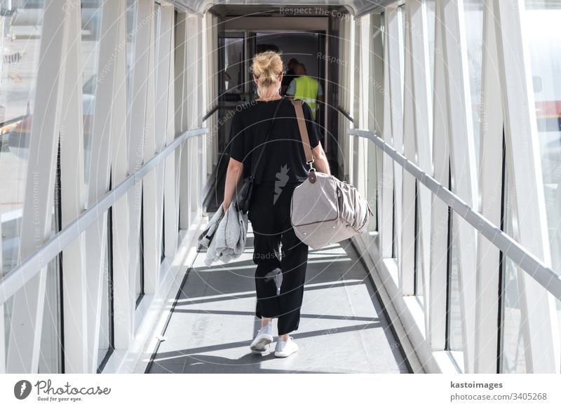 Weiblicher Passagier, der die Handgepäck-Tasche trägt, geht durch den Einstiegskorridor des Flugzeugs. reisen Fluggerät Frau Ebene transferieren Verkehr