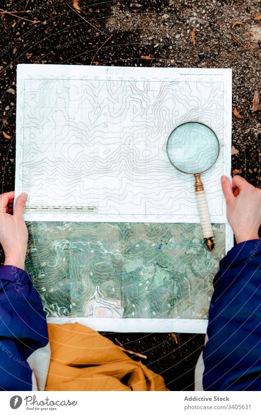 Nicht erkennbarer Wanderer, der mit Karte und Kompass in der Landschaft navigiert navigieren Landkarte Reisender prüfen topographische Karte Lupe Boden Gerät