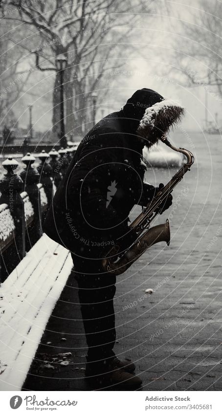 Anonymer Mann mit Saxophon auf Stadtstraße spielen Winter Straße Großstadt modern Jacke Musik Melodie Klang Instrument männlich unterhalten Lifestyle Saison
