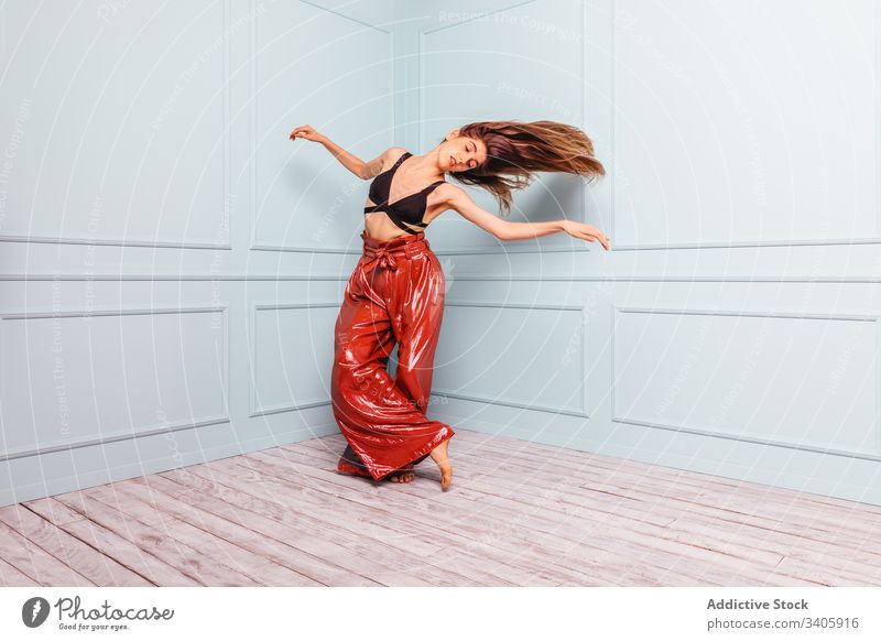 Stilvolle Tänzerin tanzt in einer Ecke des Studios Frau Tanzen springen Haare schütteln modern Eckstoß schlank elegant Model trendy Outfit Glamour